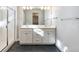 Bright bathroom featuring dual sinks, modern fixtures, a tiled shower with glass door, and sleek finishes at 21234 E 63Rd Dr, Aurora, CO 80019