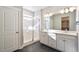 Bright bathroom featuring dual sinks, modern fixtures, a tiled shower with glass door, and sleek finishes at 21234 E 63Rd Dr, Aurora, CO 80019