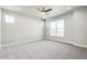 Spacious bedroom with neutral walls, carpet flooring, ceiling fan, and natural light from the windows at 21234 E 63Rd Dr, Aurora, CO 80019