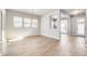 Bright dining room featuring light wood floors, a modern chandelier, and large windows for ample natural light at 21234 E 63Rd Dr, Aurora, CO 80019