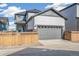 Exterior view of a gray two car garage with a wooden fence at 21234 E 63Rd Dr, Aurora, CO 80019