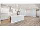 Open concept kitchen with stainless steel appliances, a white island, and a herringbone backsplash at 21234 E 63Rd Dr, Aurora, CO 80019