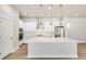 Bright modern kitchen with white cabinets, stainless steel appliances, and a large center island at 21234 E 63Rd Dr, Aurora, CO 80019