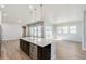 Open concept kitchen featuring a large island with seating, stainless appliances, and light wood floors at 21234 E 63Rd Dr, Aurora, CO 80019