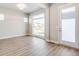 Welcoming living room featuring light wood floors, large windows, and a front door, creating a cozy ambiance at 21234 E 63Rd Dr, Aurora, CO 80019