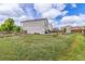 Spacious backyard featuring a well-maintained lawn, fire pit, and garden area at 249 Vista Blvd, Brighton, CO 80603