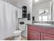 Bathroom featuring a single sink vanity, toilet, shower with white curtain, and storage at 249 Vista Blvd, Brighton, CO 80603