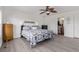 Well-lit main bedroom featuring wood-look floors, stylish decor, and an en-suite bathroom at 249 Vista Blvd, Brighton, CO 80603