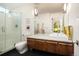 Bright bathroom features walk-in shower with glass door, commode, and vanity with marble countertop at 5969 S Humboldt Ct, Centennial, CO 80121