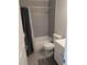 Bathroom features a modern, tiled shower-tub with a gray curtain and a white toilet and vanity at 2870 S Ursula St, Aurora, CO 80014
