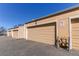 Tan detached garages in a row with an asphalt parking area on a bright sunny day at 2870 S Ursula St, Aurora, CO 80014