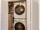 A laundry closet features a stacked Samsung washer and dryer with shelves above for storage at 2870 S Ursula St, Aurora, CO 80014