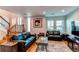Open-concept space with living room, stairs, hardwood floors, and large sunny windows at 2870 S Ursula St, Aurora, CO 80014