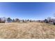 A large open field with blue homes in the background under a clear blue sky at 2870 S Ursula St, Aurora, CO 80014
