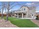 Well-maintained backyard features an artificial lawn, mature trees, covered patio, and outdoor entertaining space at 6681 Secrest Cir, Arvada, CO 80007