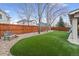 Private backyard with artificial grass, lush landscaping, stone features, and wood fence at 6681 Secrest Cir, Arvada, CO 80007