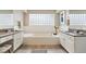 Bright bathroom with a soaking tub, and vanities, and decorative lighting at 6681 Secrest Cir, Arvada, CO 80007