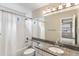 Bright bathroom with a granite vanity, shower-tub combo, and modern fixtures at 6681 Secrest Cir, Arvada, CO 80007
