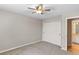 Clean bedroom with a ceiling fan, closet, neutral carpet, and a door to bathroom at 6681 Secrest Cir, Arvada, CO 80007