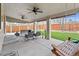 Covered patio with ceiling fans, comfortable seating, and artificial grass at 6681 Secrest Cir, Arvada, CO 80007