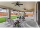 Large covered patio with ceiling fans, outdoor seating, mature trees, and backyard access at 6681 Secrest Cir, Arvada, CO 80007