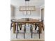 Elegant dining room with wood table, six chairs, and modern lighting fixture at 6681 Secrest Cir, Arvada, CO 80007