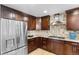 Modern kitchen with stainless steel refrigerator and gas cooktop at 6681 Secrest Cir, Arvada, CO 80007
