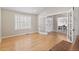 Sunlit living room featuring beautiful wood floors, shuttered windows, and open access through white French doors at 6681 Secrest Cir, Arvada, CO 80007