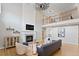 Cozy living room with a fireplace, hardwood floors, and a second-floor balcony with iron railings at 6681 Secrest Cir, Arvada, CO 80007