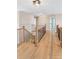 Second story loft featuring hardwood floors, dark iron railings, modern light fixture, and bright natural light at 6681 Secrest Cir, Arvada, CO 80007