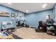 Versatile basement space with blue walls, laminate floors, and workout equipment at 1977 S Oakland Way, Aurora, CO 80014