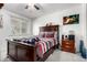 A cozy bedroom with a ceiling fan and a wooden bed frame, bedside table, and a plush comforter at 1977 S Oakland Way, Aurora, CO 80014