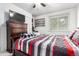 Bedroom featuring a ceiling fan, window, and wooden dresser and bedframe with a colorful striped comforter at 1977 S Oakland Way, Aurora, CO 80014