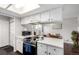 Kitchen with white cabinets, dark flooring and stainless appliances, including an oven, range, and microwave at 1977 S Oakland Way, Aurora, CO 80014