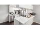 Bright kitchen features stainless appliances, white cabinets, and a peninsula with a quartz countertop at 1977 S Oakland Way, Aurora, CO 80014
