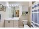 Bright bathroom with vanity, mirror, and cabinet, complemented by striped shower curtain at 1335 Villa Grv # 30, Monument, CO 80132