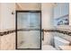 Modern bathroom featuring a glass shower enclosure with decorative mosaic tile and updated fixtures at 1335 Villa Grv # 30, Monument, CO 80132