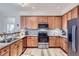 Charming kitchen featuring wooden cabinets, stainless steel appliances, and stone countertops at 1335 Villa Grv # 30, Monument, CO 80132