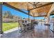 Covered back porch area with an outdoor dining set, BBQ, and spacious patio with grass at 5912 Randolph Ave, Castle Rock, CO 80104