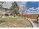 Spacious backyard with a well-manicured lawn, patio area, mature trees, and a privacy fence at 1062 Jasper St, Aurora, CO 80011
