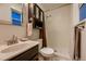 Bathroom with a shower, toilet, cabinet and sink and a window at 1062 Jasper St, Aurora, CO 80011
