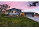 Charming two-story home with landscaped lawn, covered porch, and attached two-car garage at dusk at 1062 Jasper St, Aurora, CO 80011