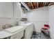 A simple laundry room with sink and white washing machine at 1062 Jasper St, Aurora, CO 80011