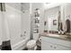 Well-lit bathroom featuring a tiled shower-tub, decorative towel rack, and a modern vanity with taupe countertop at 12570 Boggs St, Parker, CO 80134