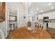 Bright dining room with a chandelier, leading to the kitchen and a conveniently located half-bathroom at 12570 Boggs St, Parker, CO 80134