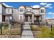 Attractive townhome featuring a stone accent facade, a well-maintained lawn, and a charming fenced-in yard at 12570 Boggs St, Parker, CO 80134