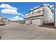 Modern townhomes featuring attached two-car garages, light-colored siding, and long concrete driveways on a sunny day at 12570 Boggs St, Parker, CO 80134