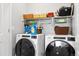 Functional laundry room equipped with modern appliances and built-in storage shelves at 12570 Boggs St, Parker, CO 80134