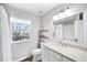 Bright bathroom with granite countertops, white cabinets, and view from the window at 230 W Jamison Cir # 31, Littleton, CO 80120