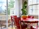 Charming breakfast nook features a retro red table and chairs, adding a pop of color to the sunlit space at 230 W Jamison Cir # 31, Littleton, CO 80120